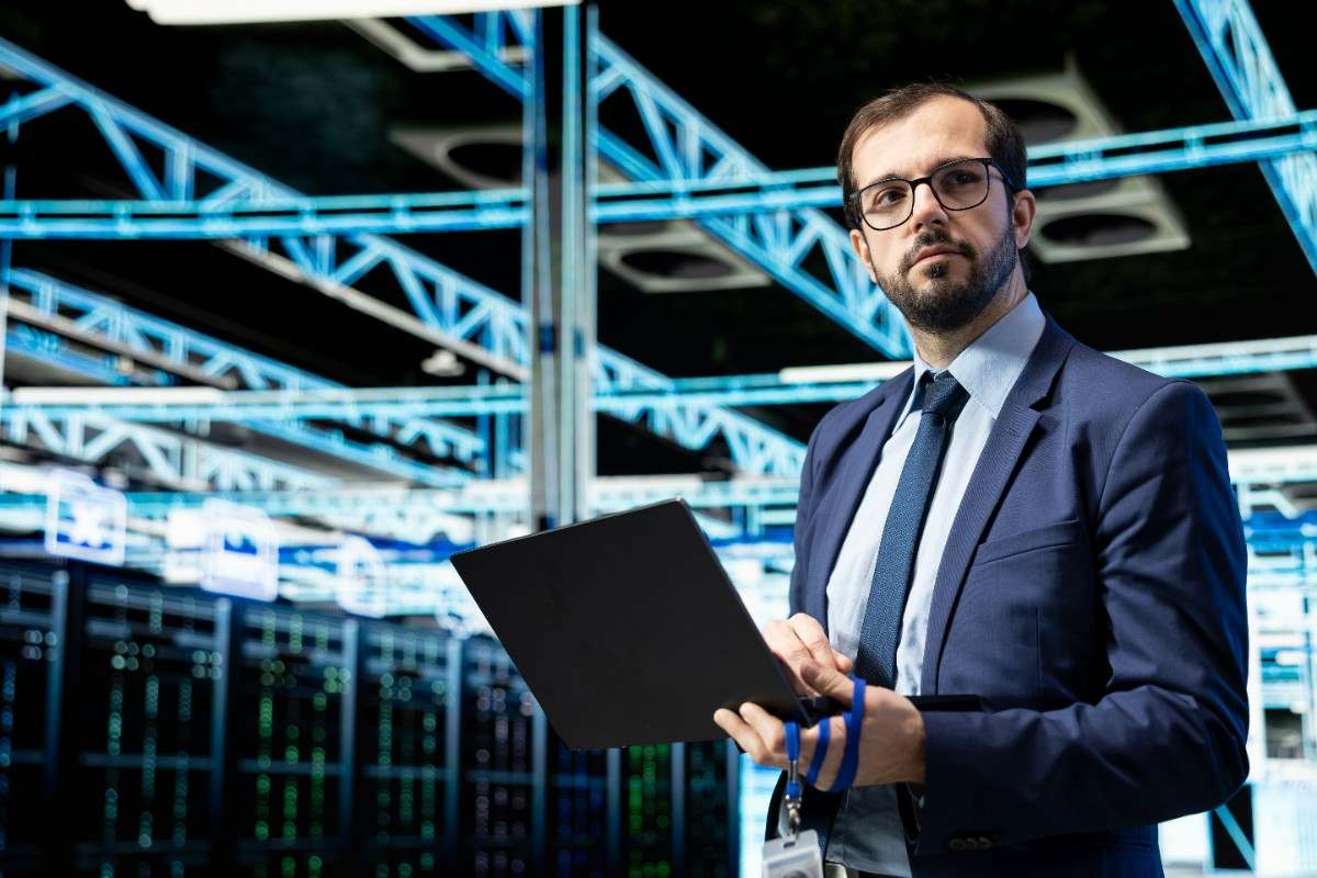 a man standing holding a laptop