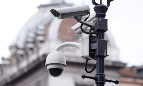 An assortment of video surveillance cameras mounted on light post net to a building